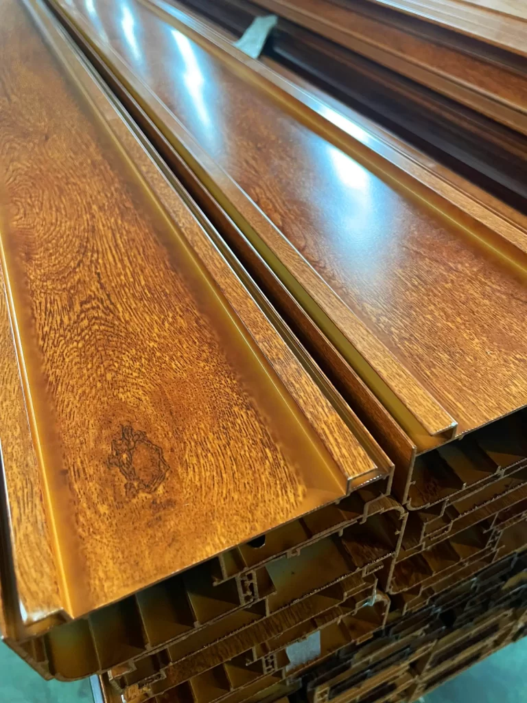 Nhôm phủ film vân gỗ có mặt cắt nhôm định hình xếp chồng trong xưởng