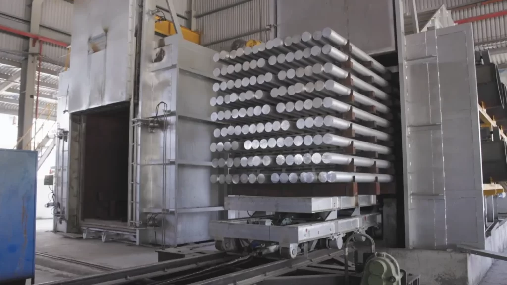 Lò luyện kim của Nhà máy Nhôm Cầu Thịnh với xe đẩy chứa nhiều phôi nhôm tròn xếp thành từng lớp chuẩn bị đưa vào lò nung.