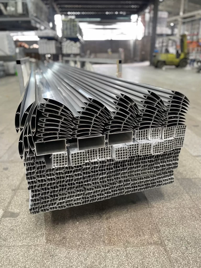 Thanh nhôm công nghiệp Nhôm Cầu Thịnh xếp chồng trong kho nhà máy với mặt cắt định hình đều nhau.